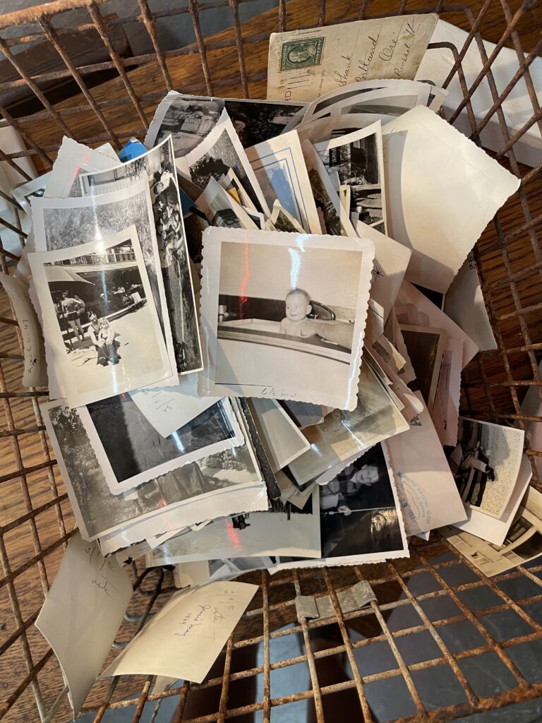 A basket of vintage photos, mostly black-and-white. 