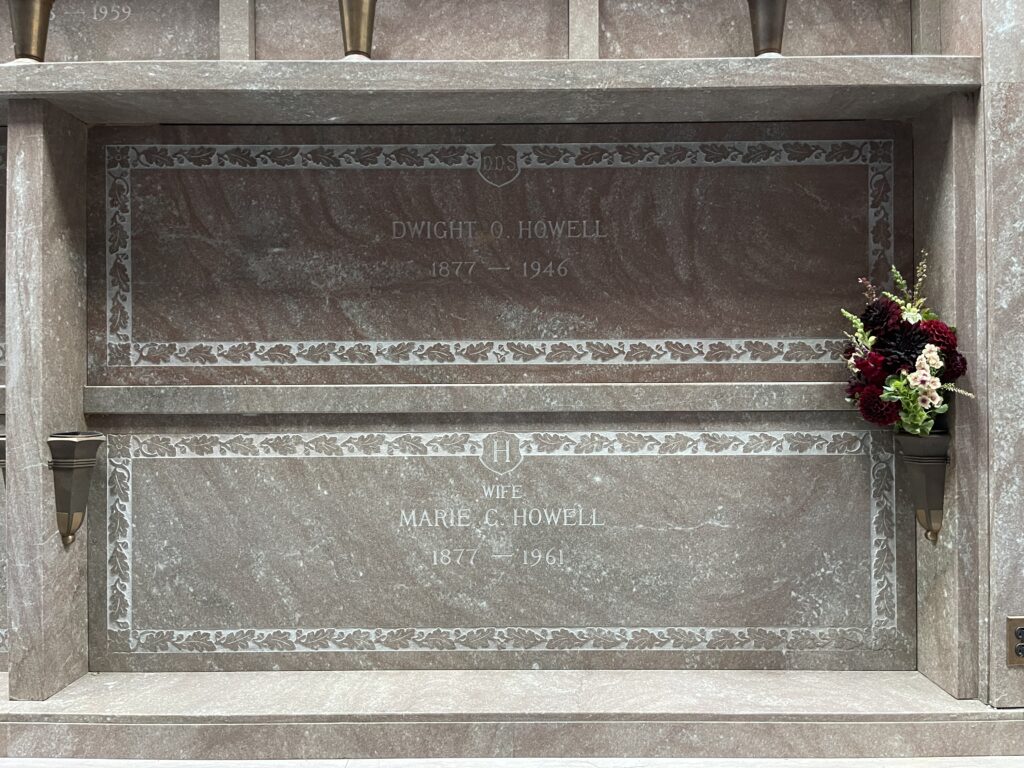 Straight-on view of the tombs/niches of Dwight O. Howell (1877-1946) and Marie C. Howell (1877-1961), with a beautiful bouquet of red dahlias in the affixed vase. 