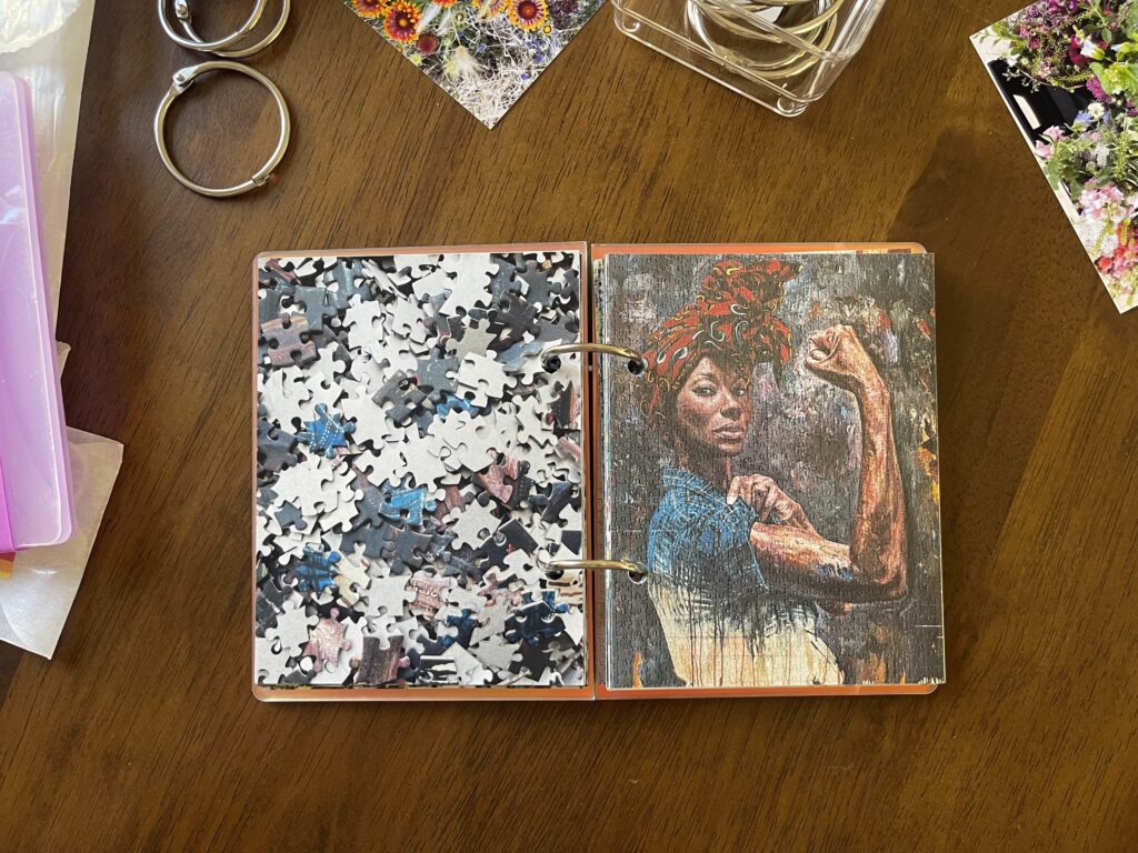 Spread #9. The left-hand page is a photo of the puzzle's unpuzzled pieces. The right-hand page is a photo of the completed puzzle of a Black woman posing as Rosie the Riveter, with her sleeve rolled up and her bicep flexed. 